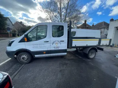 Side view of a white Ford Transit crew-cab tipper with Arborlec Services signwriting