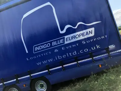 Blue Indigo Blue European curtain-side trailer with large white logo and truck outline