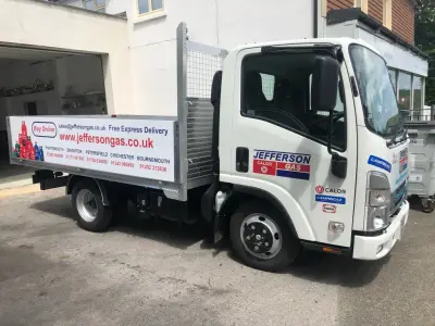 White Isuzu dropside flatbed with red and blue Jefferson Gas Calor signage on cab and bed