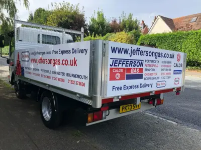 White Jefferson Gas flatbed truck, rear view, with red Calor and gas-cylinder bed signage