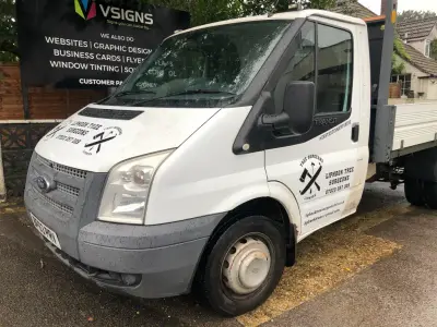 White Ford Transit tipper with black Liphook Tree Surgeons axe-and-saw logo signwriting