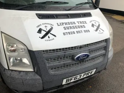 Black Liphook Tree Surgeons bonnet graphic with axe-and-saw logo on a white Ford Transit