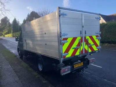 White Iveco Daily arborist tipper truck with rear red and yellow hazard chevron panel