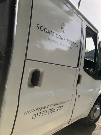 Silver Ford Transit van with grey Rogate Construction door signwriting and website