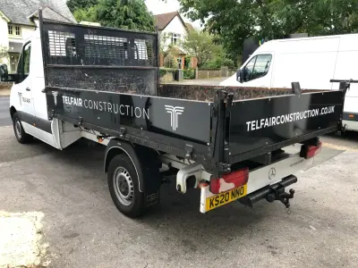White Mercedes Sprinter tipper truck with black Telfair Construction graphics both sides