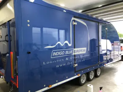 Blue enclosed car transporter trailer signwritten for Indigo Blue European logistics