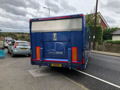 Rear of blue Indigo Blue European car transporter trailer with logo and website