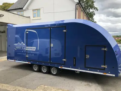 Blue Indigo Blue European enclosed car transporter trailer, angled side view