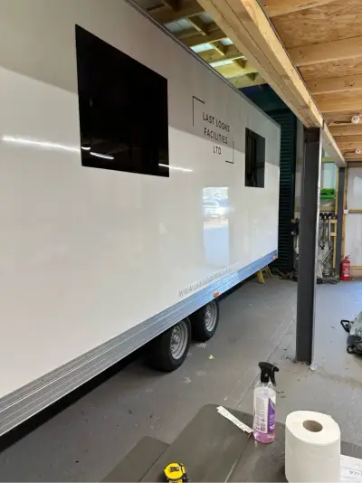 White facilities trailer with Last Looks Facilities Ltd graphics and tinted windows