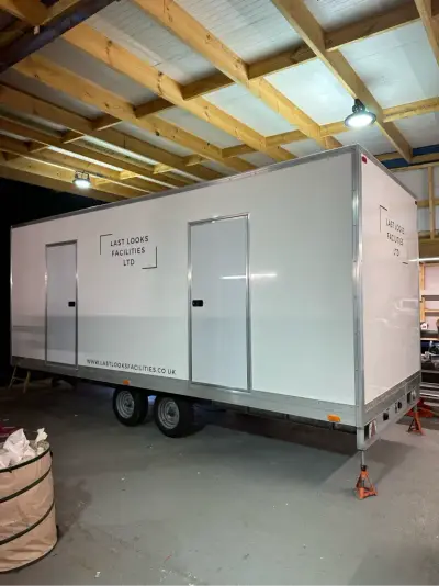 White twin-door welfare trailer with Last Looks Facilities Ltd graphics in a garage