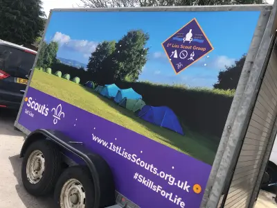 Purple and blue full wrap on 1st Liss Scout Group trailer showing tents on grass