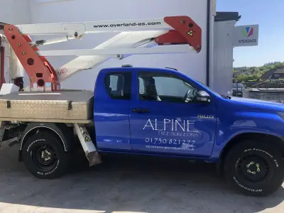 Blue Toyota Hilux access-platform truck signwritten for Alpine Tree Surgeons