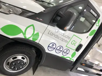 White Iveco Daily tipper with green Graduate Landscapes leaf graphics and ISO logos