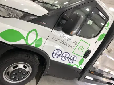 White Iveco Daily truck door with Graduate Landscapes green leaf and GL logo graphics