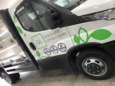 White Iveco Daily tipper cab with Graduate Landscapes leaf graphics and ISO badges