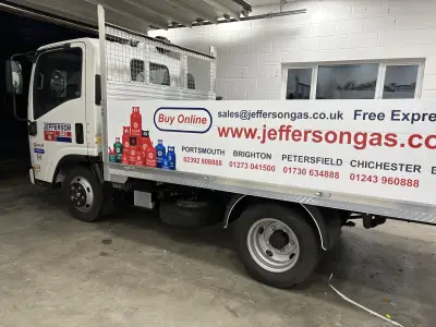 White Isuzu caged tipper truck signwritten for Jefferson Gas with Calor cylinder graphics