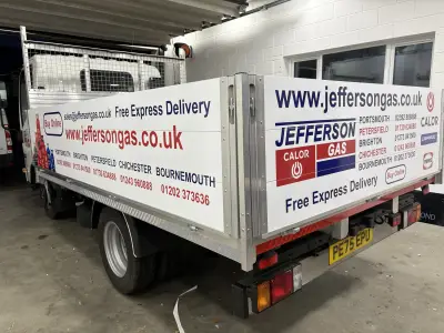 Rear of white Isuzu dropside truck with red and blue Jefferson Gas Calor branding