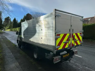 Silver aluminium tipper truck rear with red and yellow chevron markings, reg HV74 PNJ