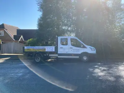 White Ford Transit crew-cab tipper, side profile with Southdowns Builders Ltd signwriting, parked kerbside