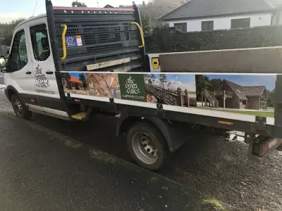 White Ford Transit flatbed with The Green Oak Carpentry Co Ltd graphics showing timber-framed buildings