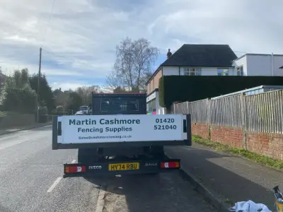 White Iveco Daily flatbed truck rear with Martin Cashmore Fencing Supplies signwriting, reg HY74 RBU