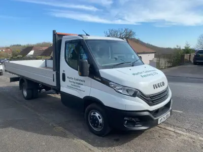 White Iveco Daily flatbed truck with Martin Cashmore Fencing Ltd door signwriting, parked kerbside
