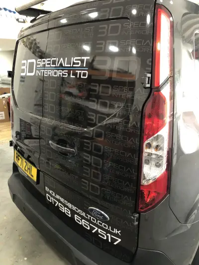 Black Ford Transit Custom van rear wrapped with repeating 3D Specialist Interiors Ltd branding, reg RF71 ZHL