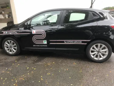 Black Renault Clio side profile with L2P Driving School graphics and phone number