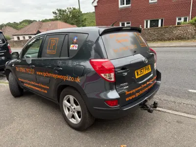 Dark grey Toyota RAV4 SUV with orange TP Chimney Sweeps window graphics and signwriting