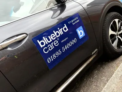 Blue Bluebird Care Hillingdon magnetic door sign fitted to a dark SUV