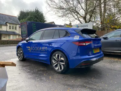 Blue Skoda Enyaq estate with full BOOKAJET wrap, rear three-quarter view