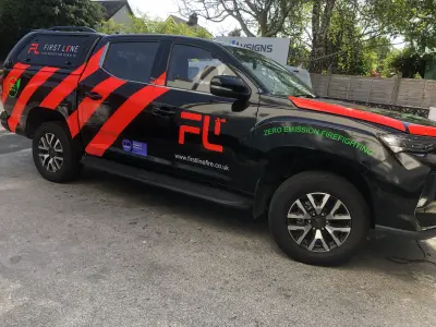 Black and red First Line firefighting pickup with FL logo and red stripes, side view