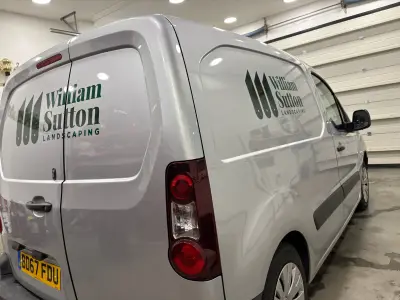 Silver Citroen Berlingo van with green William Sutton Landscaping graphics, rear three-quarter view
