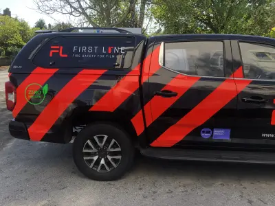 Black and red Maxus T90 EV pickup with First Line firefighting wrap, side view
