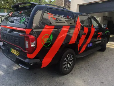 Black and red Maxus T90 EV First Line firefighting pickup, rear three-quarter view