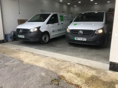 Two white Mercedes Vito Graduate Landscapes electric vans parked front-on in a garage