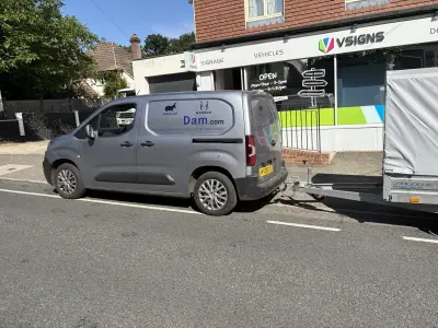 Grey van with HippoDam.com graphics towing a trailer outside the VSIGNS shopfront