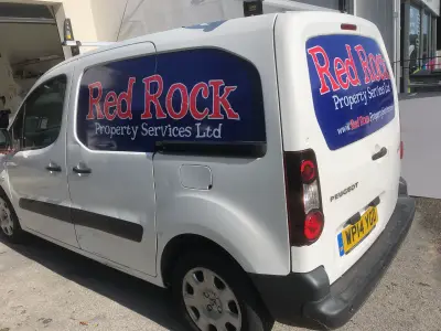 White Peugeot Partner van with blue and red Red Rock Property Services Ltd window graphics