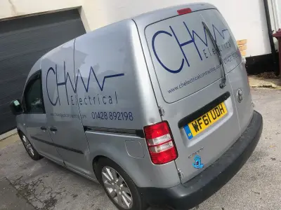 Silver Volkswagen Caddy van with blue CH Electrical logo and phone number signwriting