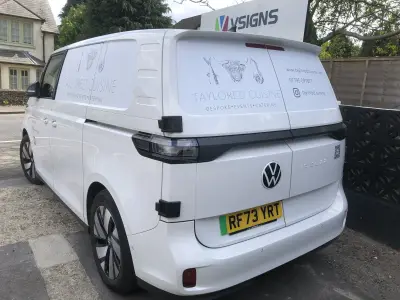 Rear three-quarter of white Volkswagen ID. Buzz signwritten for Taylored Cuisine catering