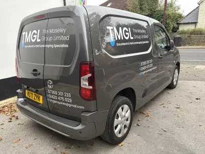 Rear three-quarter of dark grey Vauxhall Combo van signwritten for TMGL The Moseley Group Limited