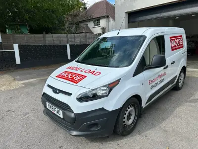 Front of white Ford Transit Connect escort van with red Moore Dump Truck Hire graphics