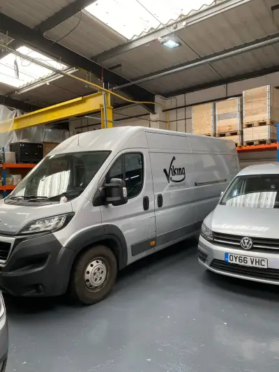Large silver Peugeot Boxer van with black Viking logo signwriting, inside a warehouse