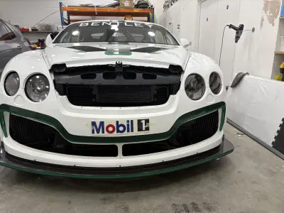 Front of white Bentley race car with BENTLEY windscreen banner and Mobil 1 graphics