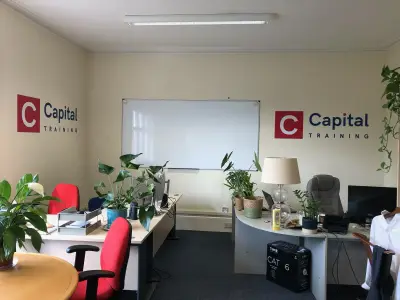 Office with red and navy Capital Training logo wall graphics on two walls