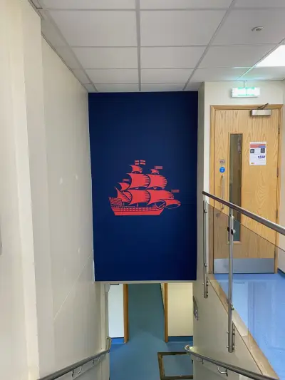 Large red galleon sailing-ship graphic on a navy wall panel in a school stairwell