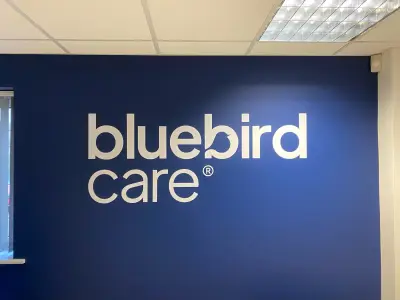 Office wall painted dark blue with large white bluebird care lettering