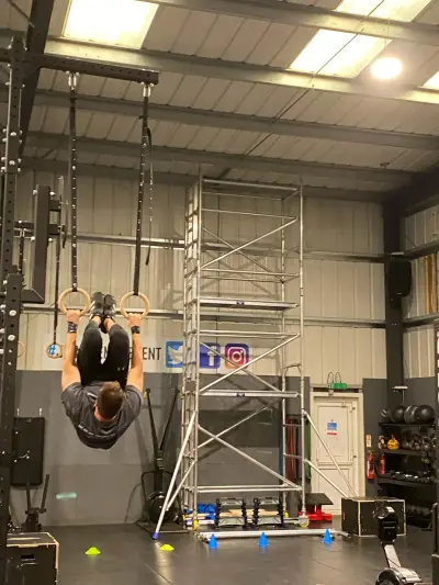 Athlete on gymnastic rings in a gym with Twitter, Facebook and Instagram logo wall graphics