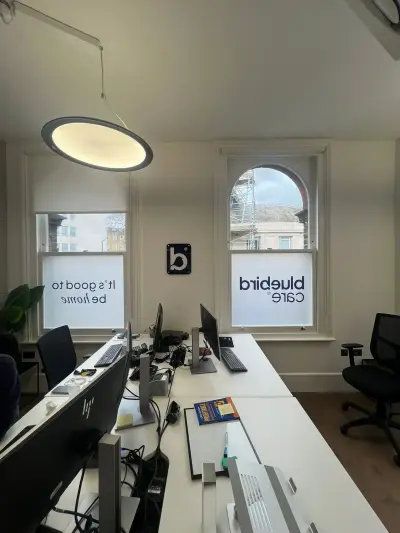Bluebird Care office windows frosted with logo and 'It's good to be home' slogan graphics