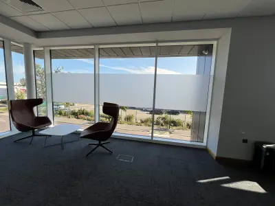 Office breakout area with frosted privacy band running across floor-to-ceiling windows